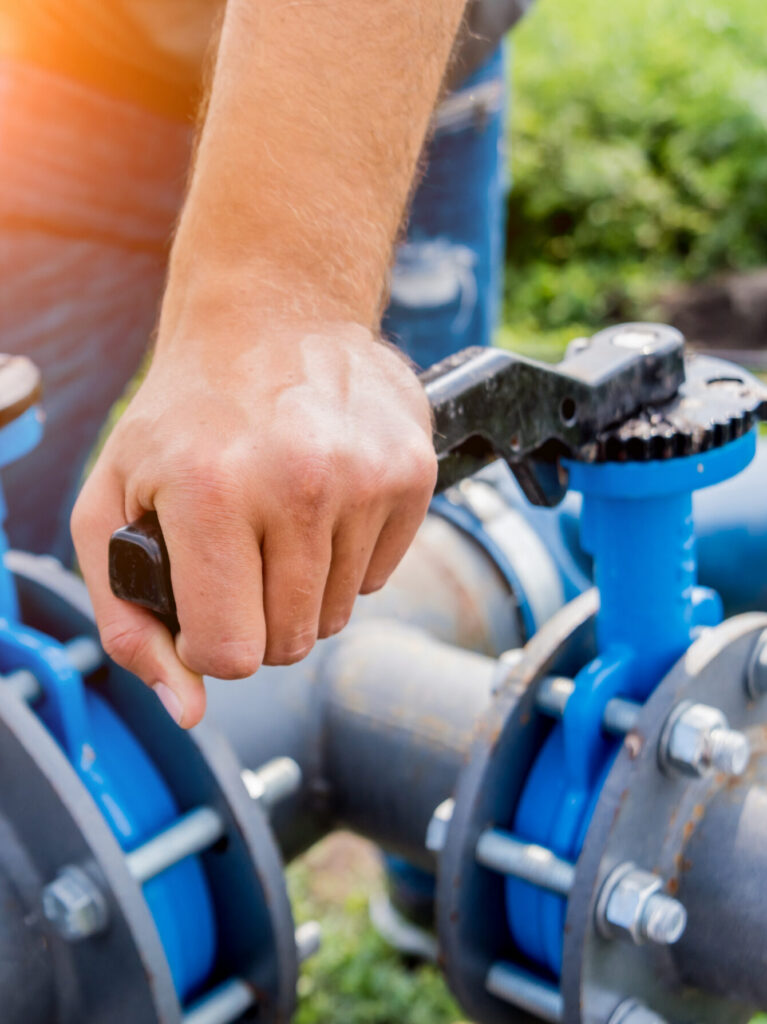 Technicien manœuvrant les vannes d'un réseau d'irrigation ou de distribution d'eau